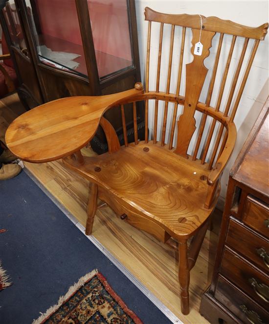 A reproduction yew and elm Windsor comb back armchair, with under seat drawer